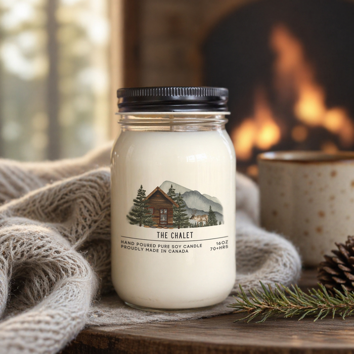 Candle labeled 'The Chalet' on a wooden surface with a cozy background